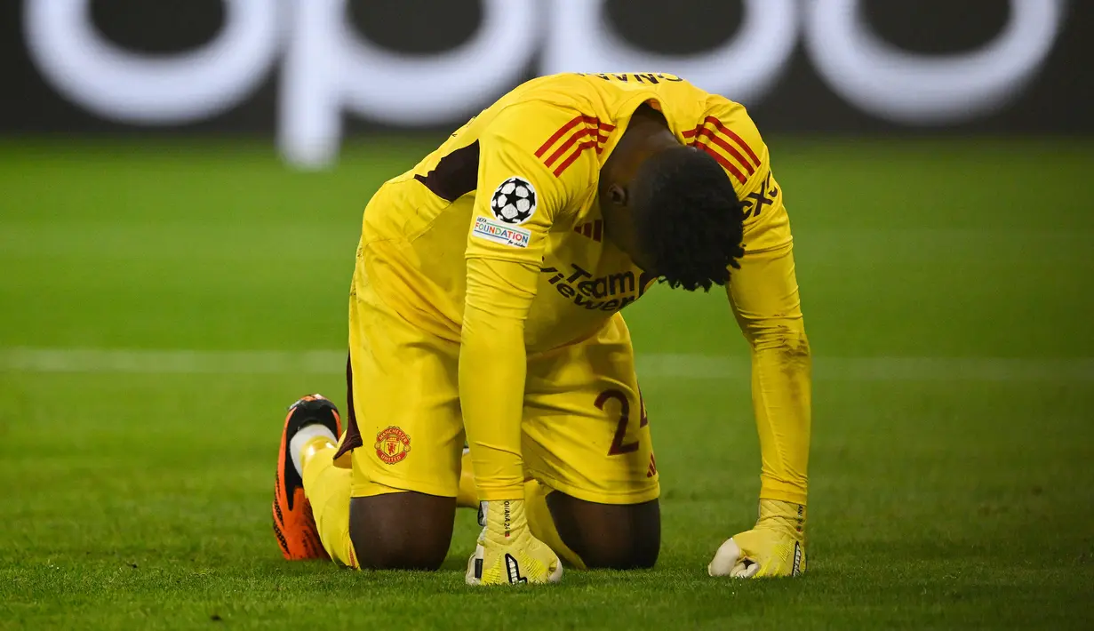 Reaksi kecewa kiper Manchester United, Andre Onana setelah kebobolan gol pertama melalui tendangan gelandang Bayern Munchen, Leroy Sane pada laga matchday pertama Grup A Liga Champions 2023/2024 di Allianz Arena, Munich, Kamis (21/9/2023) dini hari WIB. (AFP/Tobias Schwarz)