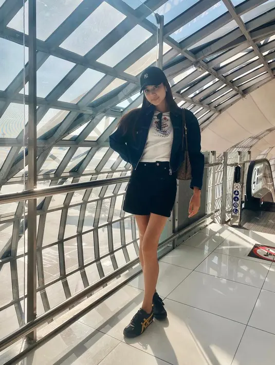 Airport look yang chic ala Mikha Tambayong. Ia mengenakan kaus putih ditumpuknya dengan cropped jacket hitam, dan celana pendek hitam, serta topi dan sneakers yang juga sama-sama berwarna hitam. [Foto: Instagram/miktambayong]