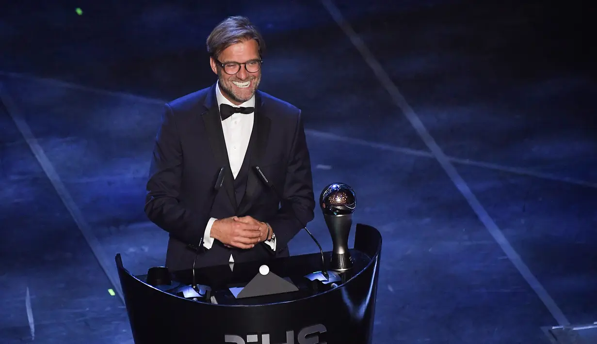 Pelatih Liverpool, Jurgen Klopp tertawa saat memberi sambutan setelah meraih Pelatih Terbaik Dunia 2019 versi FIFA saat memberi sambutan di teater La Scala Milan, Italia utara (23/9/2019). (AFP Photo/Marco Bertorello)