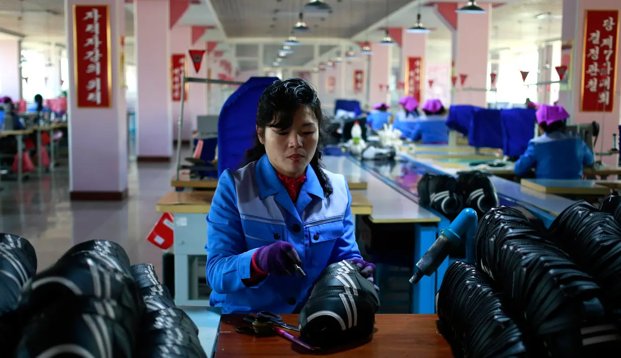 Pekerja wanita mengecek bahan sepatu di Pabrik Sepatu Ryuwon di Pyongyang, Korea Utara (1/2). Pabrik Sepatu Ryuwon merupakan spesialisasi dalam sepatu olahraga. (AP Photo/Dita Alangkara)