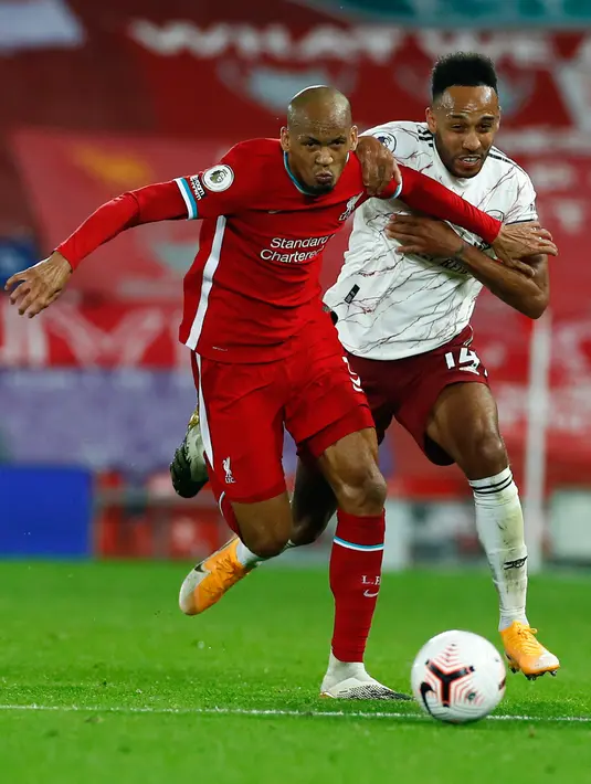 Gelandang Liverpool, Fabinho berebut bola dengan penyerang Arsenal, Pierre-Emerick Aubameyang pada pekan ketiga Liga Inggris di Anfield, Selasa dinihari WIB (29/9/2020). Tertinggal lebih dulu, Liverpool mampu membungkam Arsenal dengan skor 3-1. (Jason Cairnduff / Pool via AP)