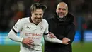 Selebrasi kemenangan gelandang Manchester City, Jack Grealish bersama pelatih Pep Guardiola setelah mengalahkan Luton Town 2-1 pada laga pekan ke-16 Liga Inggris 2023/2024 di Kenilworth Road, Luton, Minggu (10/12/2023) malam WIB. (AFP/Justin Tallis)