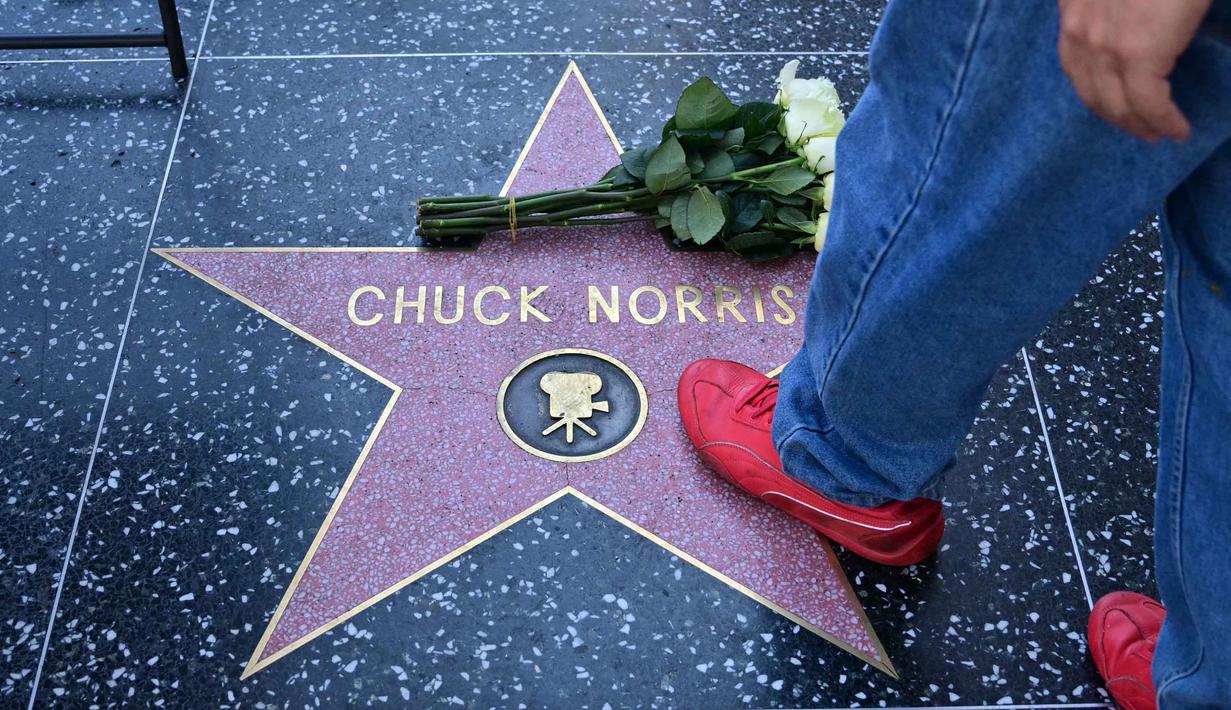 Pria yang terkenal dengan aneka film laga fenomenal ini meninggal dunia pada usia 86 tahun. Tampak dalam foto, seseorang berjalan di atas bintang Hollywood Walk of Fame Chuck Norris, menyusul berita kematiannya pada Jumat 20 Maret 2026, di Hollywood, California. (Frederic J. Brown/AFP)