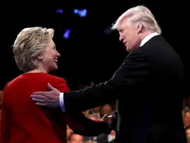 Calon presiden AS dari Partai Republik, Donald Trump menjabat tangan rivalnya dari Partai Demokrat, Hillary Clinton jelang dimulainya acara debat capres pertama di Hofstra University, New York, Senin (26/9) waktu setempat. (REUTERS/Joe Raedle/Pool)