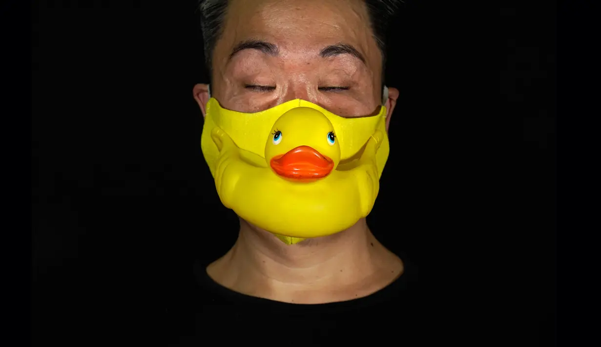 Edmond Kok, aktor dan desainer kostum teater Hong Kong, mengenakan masker wajah yang terbuat dari bebek karet di Hong Kong pada 6 Agustus 2020. Sepanjang pandemi, Edmond telah membuat lebih dari 170 masker yang terinspirasi oleh pandemi dan masalah politik Hong Kong. (AP Photo/Vincent Yu)