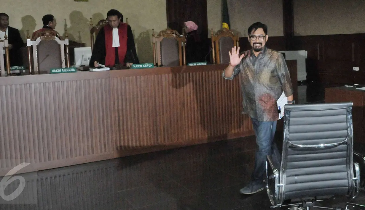 Andi Zulkarnain Mallarangeng alias Choel Mallarangeng (AZM) menyapa hadirin saat menjalani sidang perdana sebagai terdakwa untuk kasus Hambalang di pengadilan Tipikor, Jakarta, Senin (10/4). (Liputan6.com/Helmi Afandi)