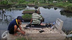 Warga mempersiapkan umpan saat memancing ikan di TPU Tanah Kusir, Jakarta Selatan, Jumat (26/8). Warga memanfaatkan Banjir yang merendam makam di kawasan tanah kusir ini terjadi akibat luapan Sungai Pesanggrahan. (Liputan6.com/Johan Tallo)