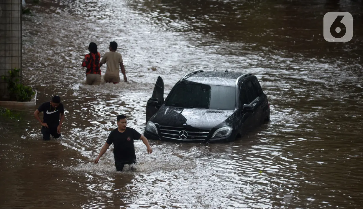 Sebuah mobil terendam banjir di Jalan Kapten Tendean, Jakarta, Sabtu (20/2/2021). Banjir yang disebabkan curah hujan tinggi memutus akses lalu lintas di Jalan Kapten Tendean. (merdeka.com/Imam Buhori)