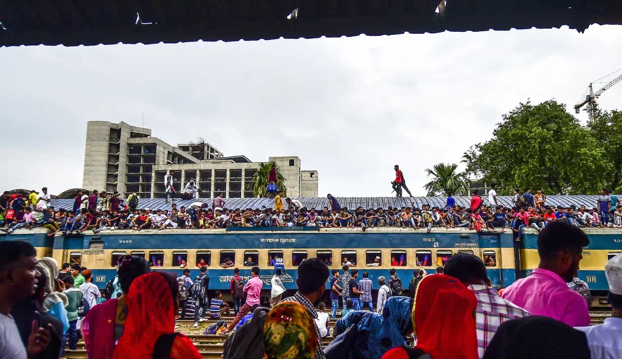 Ratusan penumpang duduk di atas atap kereta untuk menuju kampung halaman di Dhaka, Bangladesh pada 4 Juni 2019. Sebagaimana terjadi di Indonesia, masyarakat Bangladesh pun memiliki tradisi mudik saat Idul Fitri, namun agak membahayakan keselamatan. (MUNIR UZ ZAMAN/AFP)