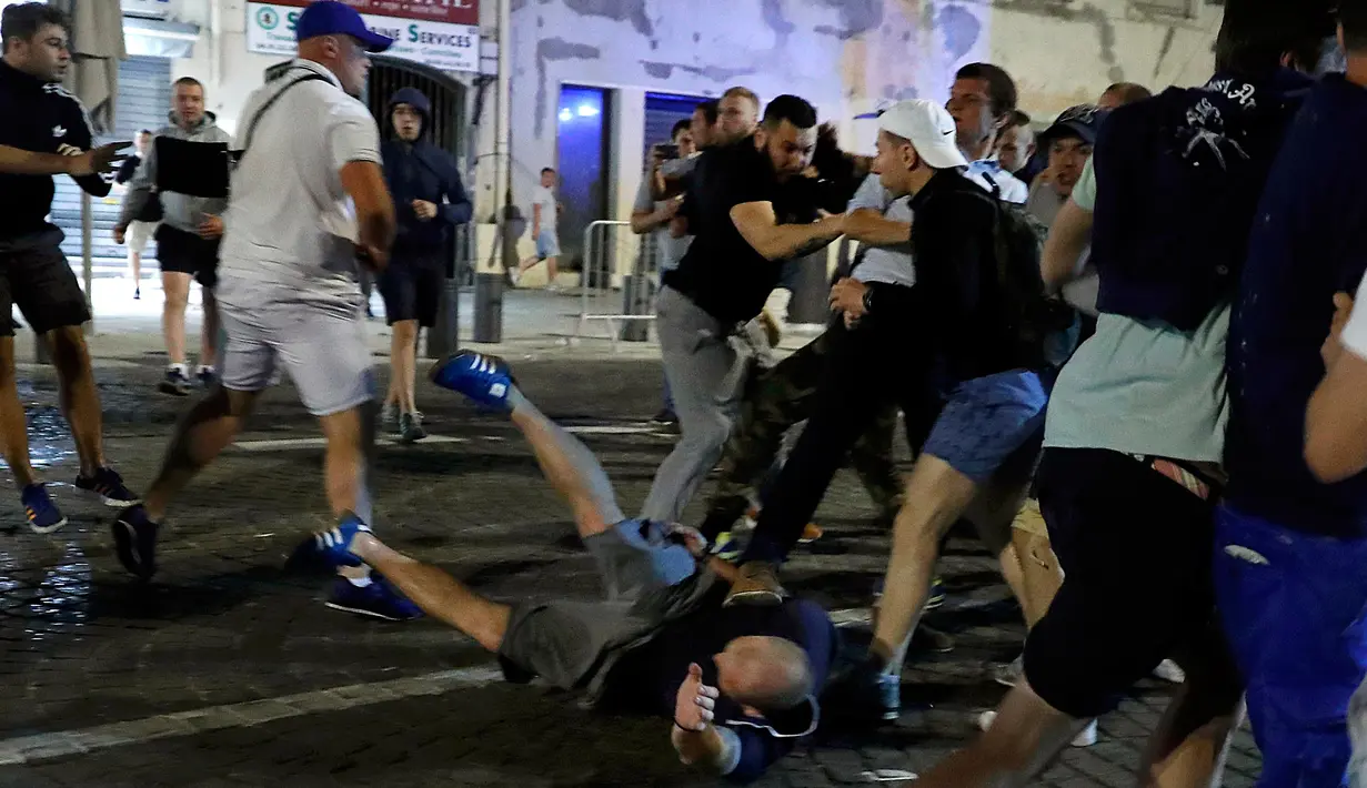 Soerang suporter terlihat terjatuh saat bentrok terjadi di kawasan bar Marseille, Prancis (10/6). Bentrokan sengit suporter Inggris dan Rusia serta pemuda lokal ini terjadi saat opening Euro 2016. (REUTERS / Eddie Keogh)