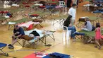 Warga yang terpaksa mengungsi akibat kebakaran hutan beristirahat di tempat penampungan sementara di sebuah gedung olahraga di La Baneza, provinsi Leon, Spanyol utara, pada 13 Agustus 2025. (CESAR MANSO/AFP)