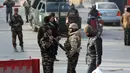 Personel keamanan Afghanistan berjaga di dekat lokasi serangan bunuh diri di Kabul, Afghanistan (25/12). Menurut sejumlah pejabat, peristiwa yang terjadi bertepatan dengan hari raya Natal itu menewaskan enam warga sipil. (AP Photo / Rahmat Gul)