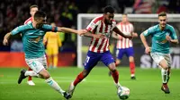 Gelandang Atletico Madrid, Thomas Lemar, berusaha melewati bek Osasuna, Oier Sanjurjo, pada laga La Liga di Stadion Wanda Metropolitano, Madrid, Sabtu (14/12). Atletico menang 2-0 atas Osasuna. (AFP/Cristina Quicler)