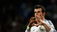Gelandang Real Madrid, Gareth Bale, membuat tanda "love" saat melakukan selebrasi usai mencetak gol ke gawang Almeria dalam laga lanjutan La Liga Spanyol di stadion Santiago Bernabeu, Madrid, (13/4/2014). (REUTERS/Susana Vera)
