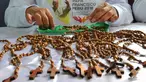 Seorang narapidana di penjara Wanita Virgen de Fatima membuat rosario kayu buatan tangan di Lima, Peru (12/1). Penjara tersebut menghasilkan 33.000 rosario untuk dijual di toko-toko ibukota Peru, Lima. (AFP Photo/Cris Bouroncle)