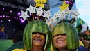 Dua orang suporter Brasil memakai helm yang terbuat dari kulit semangka, Rio de Janeiro, Brasil, Kamis (12/6/2014) (AFP PHOTO/TASSO MARCELO)