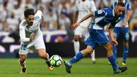 Pemain Real Madrid, Isco berebut bola dengan gelandang Espanyol, Sergi Darder dalam lanjutan La Liga 2017/2018 di Santiago Bernabeu, Minggu (1/10). Isco jadi pahlawan tim setelah memborong dua gol. (GABRIEL BOUYS/AFP)