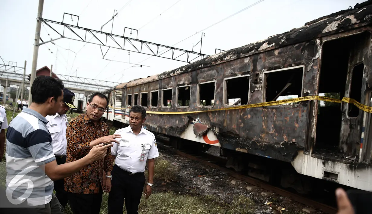 Menhub Budi Karya menyimak keterangan warga saat meninjau lokasi terbakarnya dua gerbong kereta Kerta Jaya kelas Ekonomi di dekat Stasiun Tanjung Priok, Jakarta, Kamis (25/8). (Liputan6.com/Faizal Fanani)