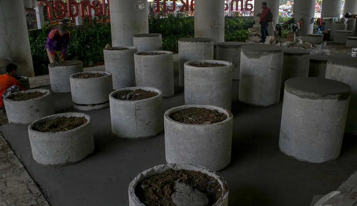 Pekerja sedang menyelesaikan pondasi meja bundar yang terbuat dari semen di Taman Aktif of Klender, Jakarta, Senin (22/9/2014) (Liputan6.com/Faizal Fanani)
