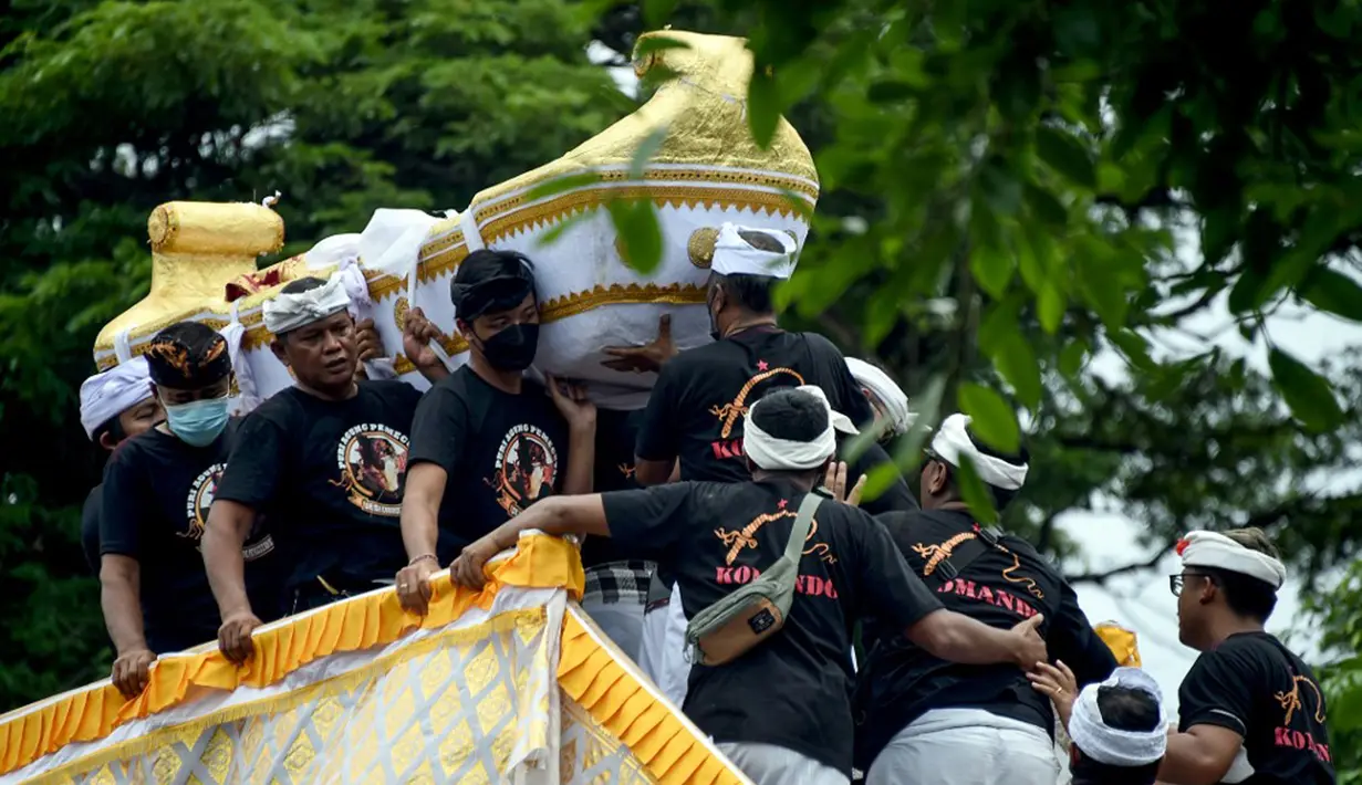 Orang-orang membawa jenazah mendiang Raja Ida Cokorda Pemecutan XI atau Anak Agung Ngurah Manik Parasara saat upacara ngaben di Denpasar, Bali, 21 Januari 2022. Anak Agung Ngurah Manik Parasara meninggal pada Desember lalu di usia 76 tahun. (SONY TUMBELAKA/AFP)