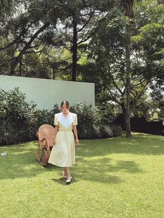 Berpose di taman, Nadin tampil cantik mengenakan midi dress kuning dengan collar  (Instagram/cakecaine).