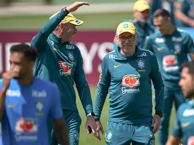 Pelatih kepala Tim Nasional (Timnas) Brasil asal Italia, Carlo Ancelotti (tengah), tersenyum di samping penyerang Raphinha (kanan) selama sesi latihan sebagai bagian dari persiapan menghadapi pertandingan sepak bola Piala Dunia 2026 melawan Maroko di Fasilitas Latihan Columbia Park, Morristown, New Jersey, pada 9 Juni 2026. (MAURO PIMENTEL/AFP)