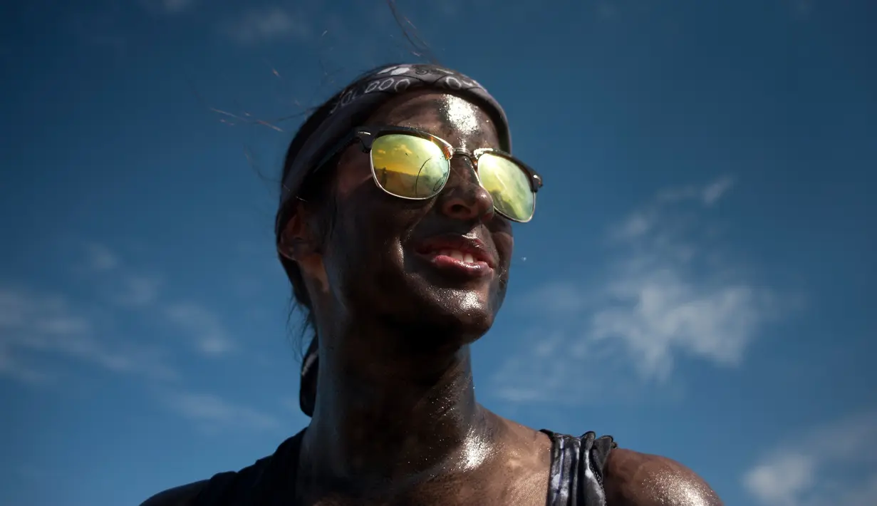 Seorang peserta dengan wajah dan seluruh tubuh yang berlumuran minyak hitam selama festival tradisional Cascamorras di Baza, Spanyol, Rabu (6/9). Festival ini merupakan tradisi warga Spanyol yang sudah dirayakan sejak 500 tahun lalu. (JORGE GUERRERO/AFP)