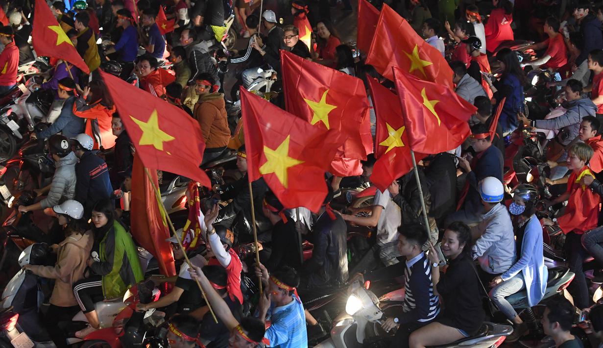 Sejumlah warga konvoi merayakan keberhasilan Vietnam mengalahkan Qatar pada semifinal Piala AFC U-23 di Hanoi, Rabu (23/1/2018). Vietnam berhasil lolos ke final untuk menantang pemenang antara Uzbekistan dan Korea Selatan. (AFP/Hoang Dinh Nam)