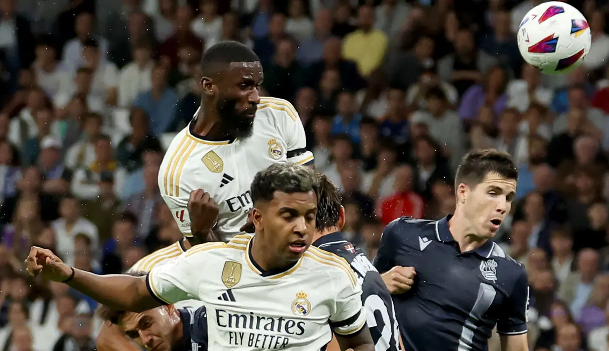 Bek Real Madrid, Antonio Rudiger (atas) menyundul bola dalam sebuah kemelut di depan gawang Real Sociedad pada laga pekan kelima Liga Spanyol 2023/2024 di Santiago Bernabéu Stadium, Madrid, Senin (18/9/2023) dini hari WIB. (AFP/Pierre-Philippe Marcou)