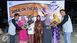 Ketua Pelakasana Sahur On The Boat 3 Angga B Nugraha bersama Pembina Jurnalis Joran Indonesia (Jojoners) Pratama D Persadha paket Ramadhan  kepada warga pesisir Pelabuhan Karangantu, Serang, Banten, Sabtu (11/6). (Dok/Jojoners)