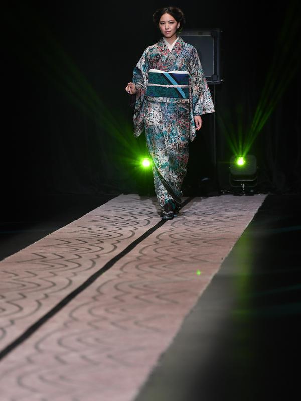 Model berjalan di atas catwalk mengenakan kimono rancangan desainer Jepang, Jotaro Saito untuk koleksi Fall Winter 2019/2020 pada Tokyo Fashion Week di Tokyo, Rabu (20/3/2019). (Photo by Toshifumi KITAMURA / AFP)