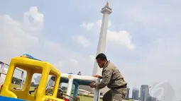 Petugas Satpol PP merapikan beberapa barang milik pedagang kaki lima yang disita di kawasan Monumen Nasional, Jakarta, (31/7/2014). (Liputan6.com/Faizal Fanani)   