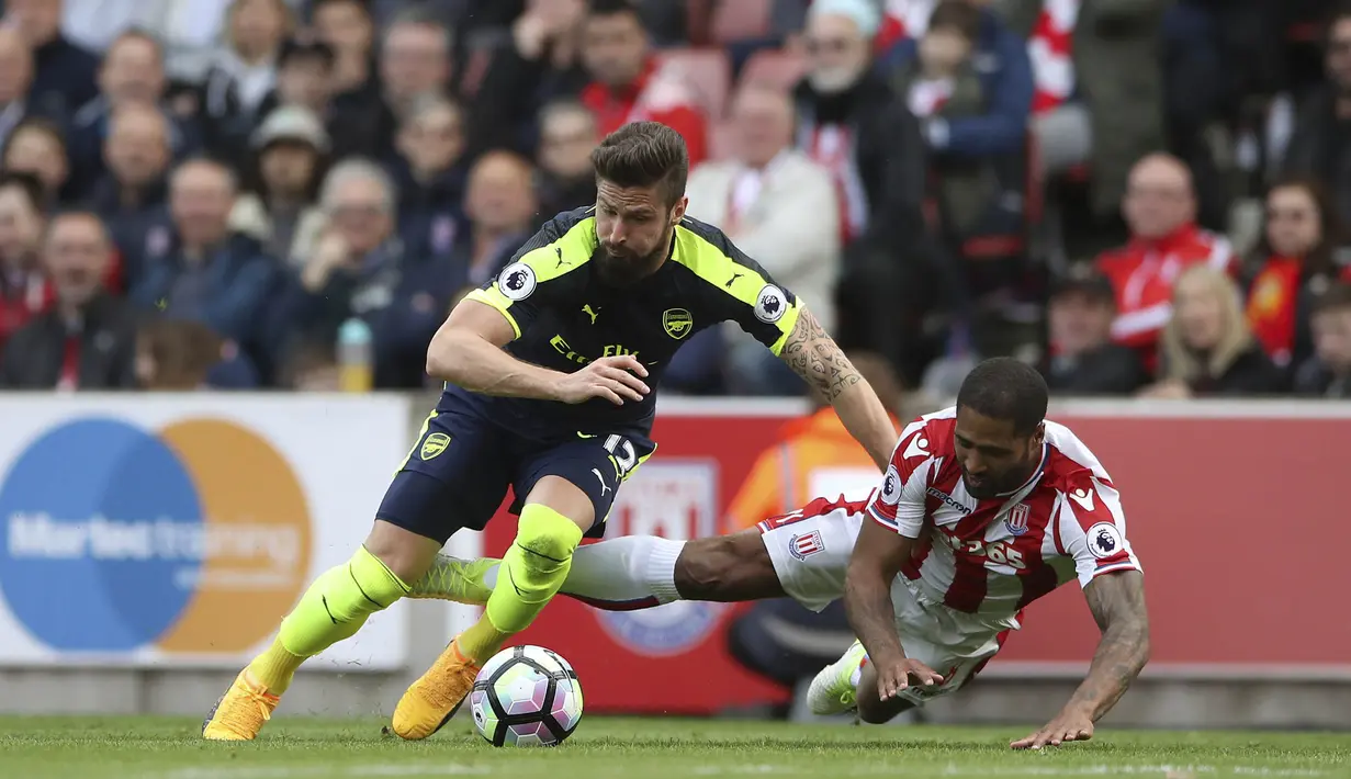 Striker Arsenal, Olivier Giroud, berusaha melewati bek Stoke City, Glen Johnson pada pertandingan pekan ke-37 Premier League, di Stadion Bet 365, Sabtu (13/5/2017). Arsenal menang dengan skor 4-1. (AP /Nick Potts)