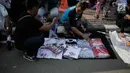 Pembeli memilih kaus #2019GantiPresiden yang dijajakan pedagang saat Car Free Day di Bundaran HI, Jakarta, Minggu (29/4). Memanasnya suasana politik nasional dimanfaatkan pedagang berjualan atribut #2019GantiPresiden. (Liputan6.com/Faizal Fanani)