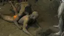 Seorang pegulat berusaha mengunci lawannya saat pertarungan gulat tradisional di festival Nag Panchami di Allahabad, India, (7/8). Festival ini diadakan selama musim hujan dengan doa dan upeti untuk ular. (AFP PHOTO/SANJAY Kanojia)