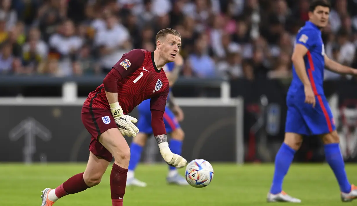 Penjaga gawang Inggris Jordan Pickford mengumpan bola saat bertanding melawan Jerman pada pertandingan Grup A3 UEFA Nations League di Allianz Arena, Munich, Rabu (8/6/2022). Inggris bermain imbang dengan Jerman 1-1. (AP Photo/Markus Ulmer)