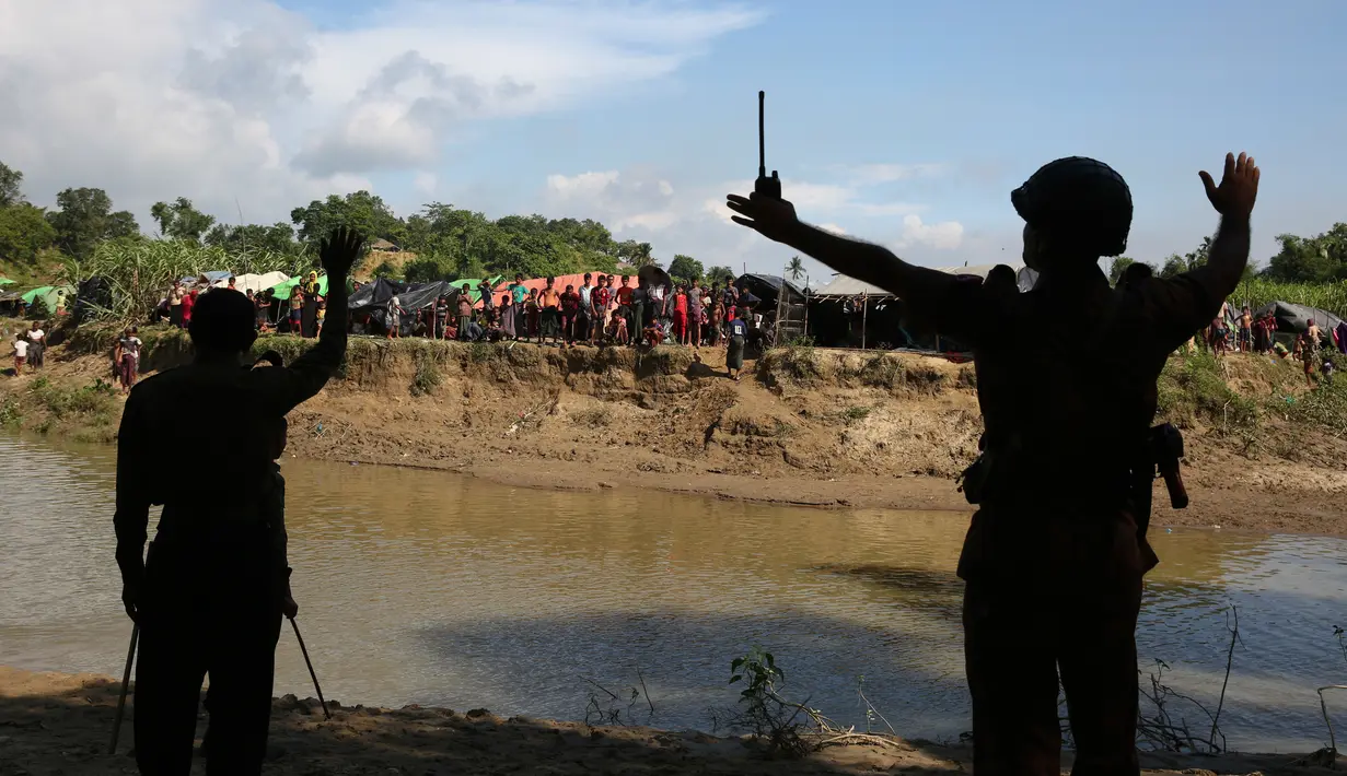 Penjaga Perbatasan Bangladesh (BJB) menghadang warga Rohingya di Ghumdhum, Cox's Bazar, Bangladesh (27/8).  Warga Rohingya berusaha menyelamatkan diri setelah bentrokan antara kelompok ARSA dan militer Myanmar pada Jumat lalu. (AP Photo/Mushfiqul Alam)