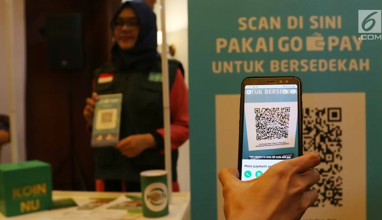 Proses scan QR Code melalui dompet digital Go-Pay saat peluncuran kerja sama strategis pemberdayaan ekonomi umat berbasis digital di Jakarta (16/7/2019). Kerja sama Gojek, Go-Pay, dan NU Care-LazisNU diharapkan dapat memudahkan 90 juta warga NU dalam bersedekah. (Liputan6.com/Angga Yuniar)