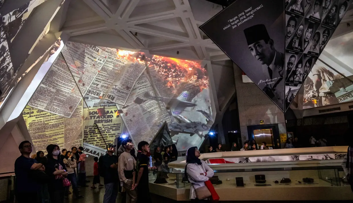 Pengunjung menyaksikan video imersif yang menggambarkan Pertempuran Surabaya, yang terjadi pada bulan November 1945 antara pejuang Indonesia melawan pasukan Sekutu Inggris dan NICA untuk menegakkan kembali kekuasaan kolonial Belanda setelah berakhirnya Perang Dunia II, dalam acara 'Malam di Museum 2025' di Museum 10 November, Surabaya, Jawa Timur, Sabtu 29 November 2025. (Juni KRISWANTO/AFP)