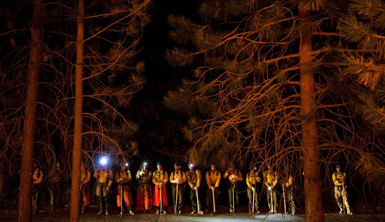 Penjaga Taman Nasional Sequoia dan petugas pemadam memantau dari kejauhan titik api yang membakar Hutan Nasional Sierra di California, AS, Jumat (21/8/2015). Mereka berusaha agar api tak menyebar luas hingga pemukiman penduduk. (REUTERS/Max Whittaker)