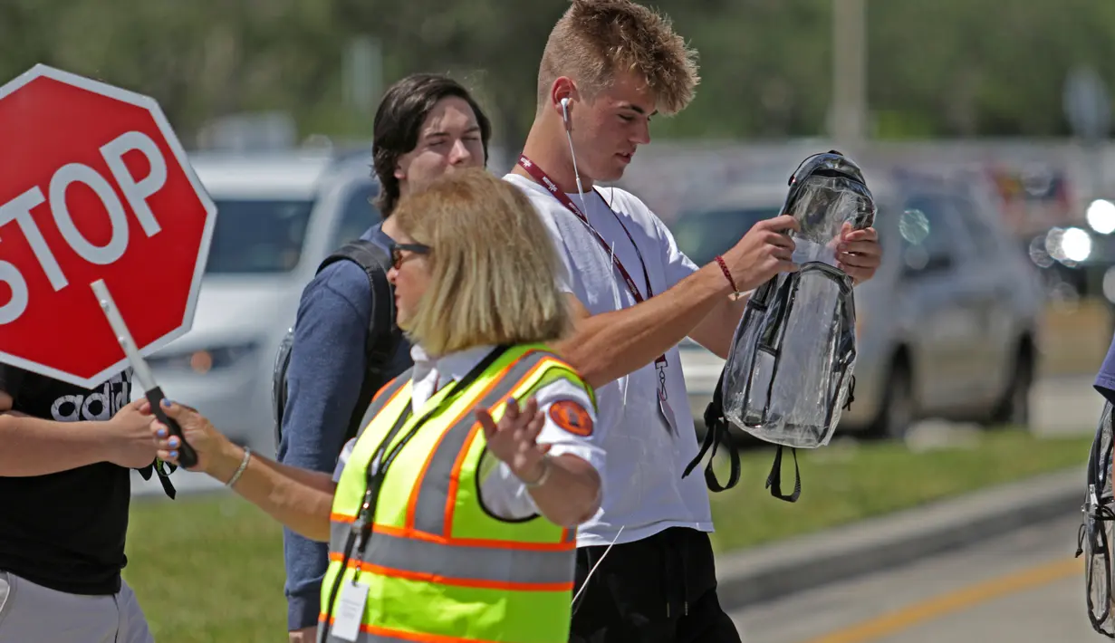 Seorang siswa SMA Marjory Stoneman Douglas memeriksa isi ransel transparan miliknya di Florida, Senin (2/4). Penggunaan tas itu bagian dari tindakan pengamanan baru untuk mengetahui barang bawaan para siswa. (John McCall/South Florida Sun-Sentinel via AP)