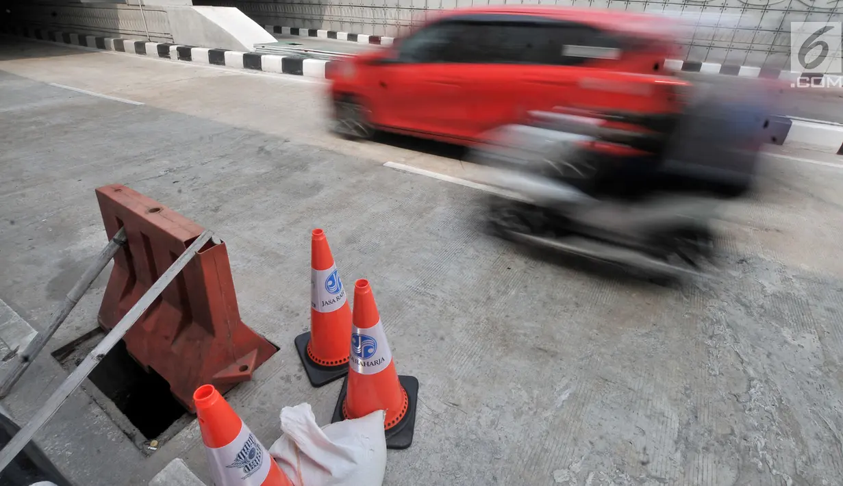 Pembatas jalan berwarna oranye diletakkan dekat penutup lubang saluran air yang hilang di Underpass Mampang-Kuningan, Jakarta, Kamis (23/8). Besi-besi penutup saluran air itu menyisakan lubang yang membahayakan pengendara. (Merdeka.com/Iqbal S. Nugroho)