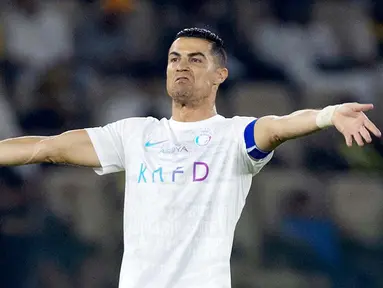 Pemain Al Nassr, Cristiano Ronaldo, melakukan selebrasi setelah mencetak gol ke gawang Al Ittihad dalam laga tunda pekan ke-17 Liga Arab Saudi di King Abdullah Sport City Stadium, Jeddah, Rabu (27/12/2023). CR7 menyumbang dua gol di laga ini. (Photo by AFP)