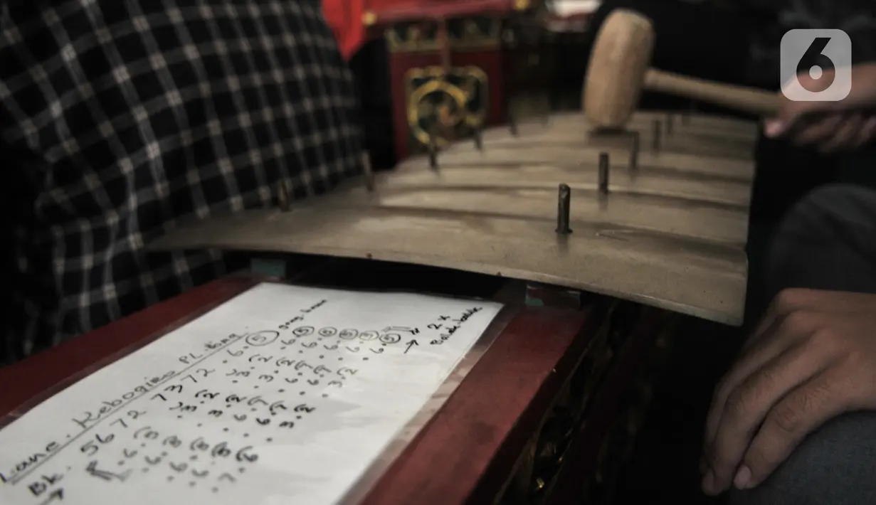 Pengunjung berlatih menjadi Nayaga atau penabuh gamelan saat lokakarya "Suara Dari Masa Lalu" di Museum Nasional, Jakarta, Minggu (22/12/2019). Lokakarya ini digelar dari 15 Desember 2019 hingga 5 Januari 2020. (merdeka.com/Iqbal S. Nugroho)