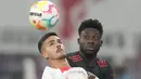 Penyerang RB Leipzig Andre Silva melakukan sundulan dengan gelandang Bayern Munchen  Alphonso Davies pada laga pekan ke-16 Bundesliga Jerman 2022-2023 di Red Bull Arena, Sabtu (21/1/2023) dini hari WIB.  RB Leipzig berhasil tahan imbang Bayern Munchen dengan skor 1-1. (AP Photo/Matthias Schrader)