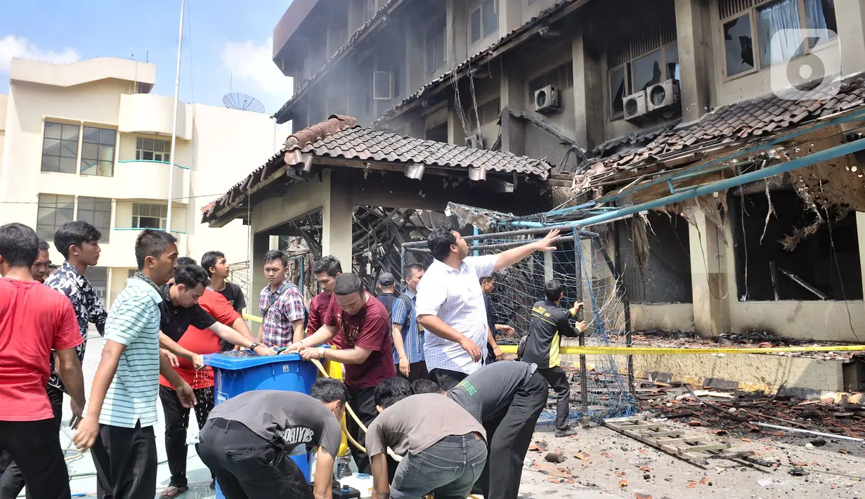 Sejumlah guru, pegawai, dan siswa berusaha memadamkan api yang kembali muncul di Gedung SMK Yadika 6, Jatiwaringin, Pondok Gede, Kota Bekasi, Jawa Barat, Selasa (19/11/2019). Kebakaran susulan ini mengejutkan sejumlah guru, siswa, dan pegawai yang tengah berada di lokasi. (merdeka.com/Iqbal Nugroho)