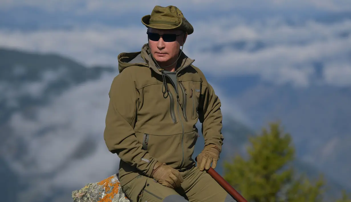 Presiden Rusia, Vladimir Putin berpose ketika menghabiskan waktu di kawasan hutan pegunungan Siberia, pada 6 Oktober 2019. Presiden Vladimir Putin menikmati hari lahirnya dengan mendaki pegunungan dan memetik jamur liar pada akhir pekan lalu. (Alexey DRUZHININ / Sputnik / AFP)