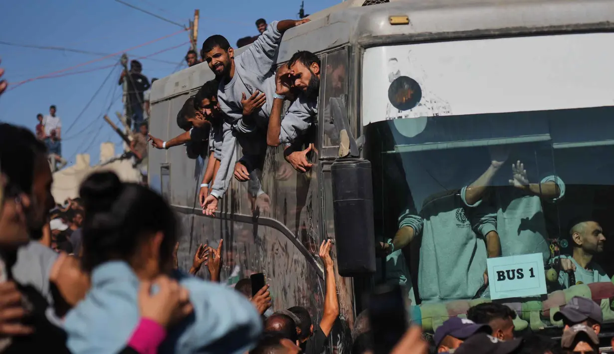 Orang-orang berkumpul untuk menyambut tahanan Palestina yang tiba dengan bus di Jalur Gaza setelah dibebaskan dari penjara Israel berdasarkan perjanjian gencatan senjata antara Hamas dan Israel, di luar Rumah Sakit Nasser di Khan Younis, bagian selatan Jalur Gaza, Senin 13 Oktober 2025. (AP Photo/Abdel Kareem Hana)