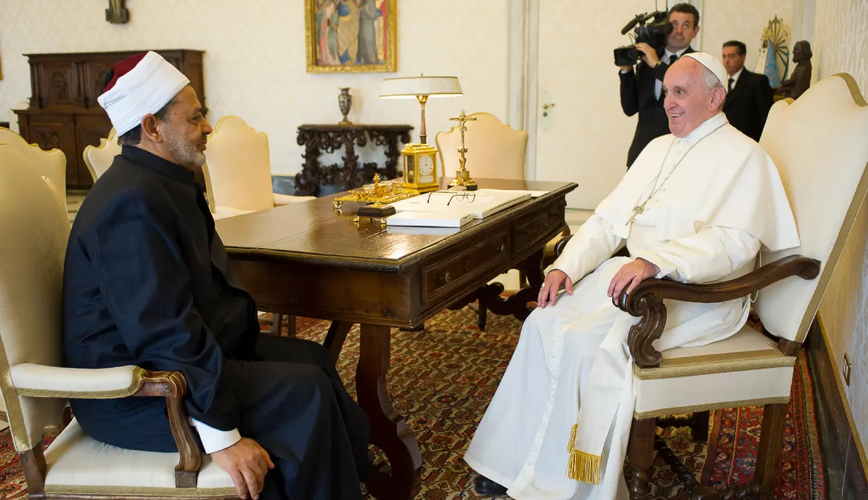 Paus Fransiskus (kanan) dan Imam Besar Al-Azhar Sheikh Ahmed Mohamed el-Tayeb tampak berbincang selama melakukan audiensi pribadi di Istana Apostolik, Vatikan, Senin (23/5). (Handout/Osservatore Romano/AFP)