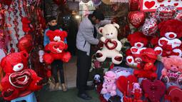 Pemilik toko mengatur boneka beruang saat menunggu pelanggan di toko suvenir pada Hari Valentine di Kabul, Afghanistan, Minggu (14/2/2021). Hari Valentine menjadi budaya baru dalam masyarakat Afghanistan yang konservatif. (AP Photo/Rahmat Gul)